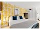 Inviting bedroom with a cozy bed, decorative yellow pineapple wallpaper, and modern furnishings at 5523 N Ocean Blvd. # 2006, Myrtle Beach, SC 29577