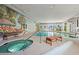 Indoor pool area featuring a jacuzzi, seating, and scenic murals at 5523 N Ocean Blvd. # 2006, Myrtle Beach, SC 29577