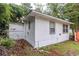 Back of house exterior with a small window, surrounded by overgrown foliage and yard debris at 609 3Rd Ave. N, Myrtle Beach, SC 29577