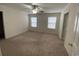 Spacious bedroom with neutral carpet, ceiling fan, and two bright windows at 618 Cypress Dr., Surfside Beach, SC 29575
