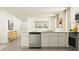 Open kitchen features an island with a stainless steel dishwasher and white cabinetry at 6331 Swainson Street Sw, Ocean Isle Beach, NC 28469