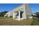 Backyard view featuring a green home, black metal fencing, and a covered back porch at 6619 Colonial Dr., Myrtle Beach, SC 29572