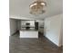 Bright eat-in kitchen with granite counters, white cabinets, and a modern decorative lighting fixture at 6619 Colonial Dr., Myrtle Beach, SC 29572