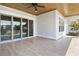Inviting covered porch with tile flooring, ceiling fan, and sliding glass doors at 6850 Belancino Blvd., Myrtle Beach, SC 29579