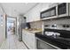 Compact kitchen with white cabinets, stainless steel appliances, and a pass-through to the living area at 6900 N Ocean Blvd. # 834, Myrtle Beach, SC 29577
