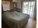Bedroom with wood-paneled walls, a queen-sized bed, and sliding glass doors at 710 S Waccamaw Dr., Garden City Beach, SC 29576