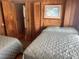 Bright bedroom showcasing two beds, wood paneling, artwork, and access to other rooms at 710 S Waccamaw Dr., Garden City Beach, SC 29576