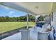 Back patio with comfortable wicker furniture and a gas grill overlooking an expansive manicured yard at 7356 Johnson Shortcut Rd., Conway, SC 29527