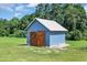 Exterior view of a small, gabled shed painted blue with light trim and a metal roof at 7356 Johnson Shortcut Rd., Conway, SC 29527