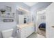 Bright bathroom features white vanity with drawers, a large mirror, and decorative wall art and an open door to bedroom at 755 Wintercreeper Dr., Longs, SC 29568