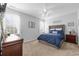 Bedroom featuring a bed with a blue comforter, two windows with coverings, and beige carpeting at 755 Wintercreeper Dr., Longs, SC 29568