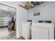 Bright laundry room featuring white washer and dryer sets, shelving, and door to the garage at 755 Wintercreeper Dr., Longs, SC 29568
