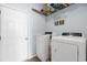Laundry room featuring white washer and dryer sets, storage shelves, and tile floors at 755 Wintercreeper Dr., Longs, SC 29568