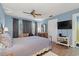 Bright bedroom featuring wood-look floors, TV, curtains, and a dresser with mirror at 800 9Th Ave. S # N-1, North Myrtle Beach, SC 29582