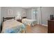 Cozy bedroom with twin beds, wood floors, and natural light from the window at 800 9Th Ave. S # N-1, North Myrtle Beach, SC 29582