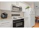 Well-lit kitchen with white cabinetry, granite countertops, and stainless steel microwave, perfect for cooking enthusiasts at 800 9Th Ave. S # N-1, North Myrtle Beach, SC 29582