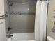 Nicely tiled bathroom with a shower, tub and a white waffle-weave shower curtain at 812 S Ocean Blvd. # B-3, Surfside Beach, SC 29575