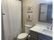 Bathroom with marble vanity, gray cabinets, and a shower with a white waffle-weave shower curtain at 812 S Ocean Blvd. # B-3, Surfside Beach, SC 29575