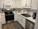 Modern kitchen with white cabinets, stainless steel appliances, and stone countertops at 812 S Ocean Blvd. # B-3, Surfside Beach, SC 29575