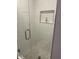 Clean shower featuring white subway tile, a built-in shelf, and a glass door at 812 S Ocean Blvd. # B-3, Surfside Beach, SC 29575