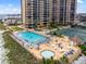 Aerial view of a large pool, jacuzzi, and tennis courts at the base of a condo complex near the beach at 9650 Shore Dr. # 507, Myrtle Beach, SC 29572
