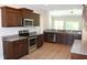 Open kitchen with stainless steel appliances, granite countertops, and dark wood cabinets at Tbd 222 Persimmon Rd., Aynor, SC 29511