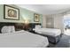 Hotel bedroom featuring two beds, abstract art, and modern decor with a balcony view at 107 S Ocean Blvd. # 503, Myrtle Beach, SC 29577