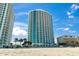 Beautiful view of a condo building with ocean views with a sandy beach in the foreground at 107 S Ocean Blvd. # 503, Myrtle Beach, SC 29577