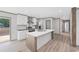 Modern kitchen features a central island, stainless steel appliances, white cabinetry and wood floors at 108 Forman Way, Aynor, SC 29511