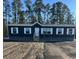 New construction home with dark siding, white trim, and professional installation of decorative stone skirting at 109 Forman Way, Aynor, SC 29511