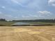 Wide view of a picturesque pond surrounded by green fields and trees, under a beautiful sky with scattered clouds at 119 Westfield Circle, Conway, SC 29526