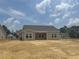 Back of home featuring neutral siding, symmetrical window design and a bright, inviting backyard under a clear sky at 119 Westfield Circle, Conway, SC 29526