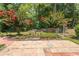 Lush backyard with flowering trees and a brick patio, creating a serene outdoor space at 123 Retreat Pl., Little River, SC 29566