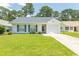 Charming single-story home featuring a well-manicured lawn and a classic white exterior at 123 Retreat Pl., Little River, SC 29566
