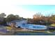Aerial view featuring the community pool, tennis courts, clubhouse, and beautiful surrounding fall foliage at 1307 Carolina Wren Ln., Murrells Inlet, SC 29576