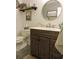 This bathroom features a wooden vanity with a marble top, a toilet, and decorative shelves and artwork at 1307 Carolina Wren Ln., Murrells Inlet, SC 29576