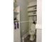 A well-lit bathroom with a toilet, decorative shelving, and vanity for personal storage at 1307 Carolina Wren Ln., Murrells Inlet, SC 29576