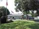 Community building with an American flag, mature tree, well manicured lawn, and golf carts parked outside at 1307 Carolina Wren Ln., Murrells Inlet, SC 29576