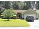 Charming single-story home featuring a well-manicured lawn, mature trees, and a two-car garage at 1307 Carolina Wren Ln., Murrells Inlet, SC 29576