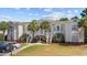Inviting condo complex with a well-manicured lawn and picturesque palm trees at 139 Avian Dr. # 6-201, Pawleys Island, SC 29585