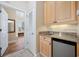 Convenient wet bar with cabinets, granite countertop, sink, and mini refrigerator at 139 Avian Dr. # 6-201, Pawleys Island, SC 29585