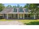 Charming home featuring a welcoming front porch with white columns and black shutters, set against a lush green lawn at 140 Pixie Dust Ct., Myrtle Beach, SC 29588
