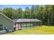 Rear exterior view of the home featuring screened-in pool, patio, and lush landscaping at 140 Pixie Dust Ct., Myrtle Beach, SC 29588