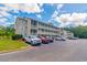 Attractive condo building with three stories of units and balconies, surrounded by lush trees and a parking lot at 1450 St. George Ln. # E, Myrtle Beach, SC 29588