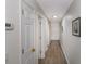 Well-lit hallway with wood floors and fresh white doors, leading to various rooms in the home at 1450 St. George Ln. # E, Myrtle Beach, SC 29588