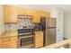 Kitchen featuring stainless steel appliances, breakfast bar with granite countertop, and wood cabinetry at 1450 St. George Ln. # E, Myrtle Beach, SC 29588