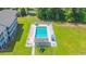 Overhead view of a fenced community pool surrounded by grass and trees next to a condo building at 1450 St. George Ln. # E, Myrtle Beach, SC 29588