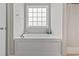 Bright bathroom features a soaking tub beneath a window, complete with chrome fixtures and towel rack at 155 Palmetto Green Dr., Longs, SC 29568