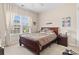 Cozy bedroom features a wooden bed frame, neutral carpet, and a bright window with curtains at 155 Palmetto Green Dr., Longs, SC 29568