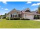 Single-story home with a charming facade, a well-kept lawn, and an American flag waving in the breeze at 155 Palmetto Green Dr., Longs, SC 29568